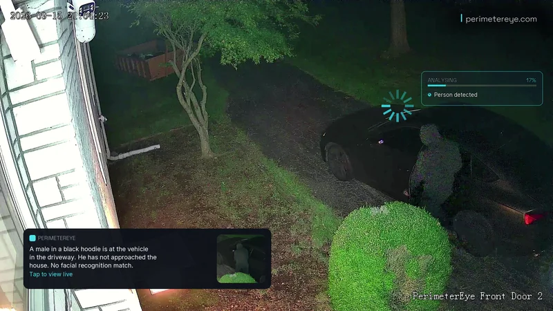 Front Door 2 camera at night: a person in a black hoodie at the parked car, the analysis panel at person detected, and the phone alert describing them